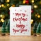 Merry Christmas on white paper, standing greeting card.