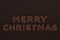 Merry Christmas words from chocolate balls on chocolate background