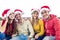 Merry christmas! Young group of friends close up portrait celebrating xmas time wearing santa claus hat sitting on a couch. family