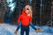 Merry couple having fun in the winter forest in red sweatshirts