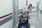 Merry doctor is pushing wheelchair with patient
