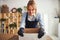 Merry floral designer leaning on an open cardboard box