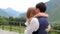 Merry groom and bride against the backdrop of high mountains. The bridegroom is circling the bride