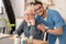 Merry male nurse hugging a pensioner in the kitchen