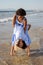 Merry mother and daughter playing on beach
