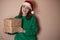 Merry surprised young woman wear xmas sweater Santa hat posing pointing hands arms aside indicate on workspace area isolated on