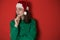 Merry surprised young woman wear xmas sweater Santa hat posing pointing hands arms aside indicate on workspace area isolated on