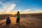 Merzouga, Morocco - October 16, 2018: Two women watching a beautiful sunrise over Erg Chebbi sand dunes near Merzouga, Morocco