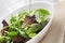 Mesclun mix salad in white bowl