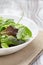 Mesclun mix salad in white bowl