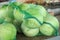 Mesh bags with fresh cabbages at market