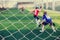 Mesh of goal with blurry of soccer goalkeeper and soccer players