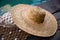 Mesh shopping bag with white towel and straw hat on concrete background. Flat lay