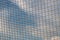 Mesh woven from a rope with a blur in the background in the rays of clear sun against the blue sky. Transparent light burrowing. D