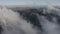 Mesmerizing aerial view of dense white clouds covering mountains