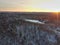 The mesmerizing beauty of a winter forest from a bird\'s eye view in golden rays
