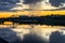 Mesmerizing blazing sunset over the mirror glossy surface of the Volga river, reflecting dramatic sky. City of Tver, Russia.