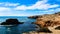 Mesmerizing blue sea in front of large rocky cliffs on a sunny day in Australia