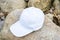 A mesmerizing mockup image captures the essence of a white blank hat harmoniously arranged within a natural setting