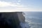 Mesmerizing scenery of ocean waves crashing into cliffs of Moher located in Ireland