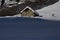 Mesmerizing shot of the hikers along a small rural house covered with snow