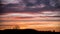 Mesmerizing sunrise over a field with the silhouette of people enjoying the calm morning