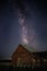 Mesmerizing vertical view of the magical starry night over an old wooden barn