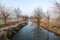 Mesmerizing view of a long and narrow lake surrounded by bare trees