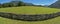 Mesmerizing view of the wooden fence in the field with the trees and mountains in the background