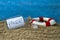 Message in a bottle with the german word for time-out or break - Auszeit on sand with lifebuoy and blue weathered wood
