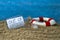 Message in a bottle in sand with message out of office in front of blue weathered wood