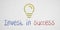 Message INVEST IN SUCCESS with light bulb icon as drawing