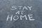 Message Stay home written on asphalt street