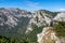 Messnerin - A man with a hiking backpack standing on the rock with a view on the Alpine mountain chains in Austria