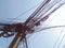 Messy cable wire on electric pole against blue sky