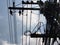 Messy cables and wires on concrete poles. The background is all clear sky.