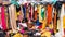 Messy clearance section in a clothing store, with colorful garments on racks and on the floor