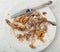 Messy Dinner Plate of chicken bones left after eating the meat off them. It`s a horizontal crop with a flat layout