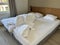 Messy double bed with white bedding sets
