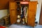 Messy old wooden wardrobe with clothes and child doll. Mucking out after Kondo: Does it spark joy? Wooden messy closet with