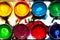 Messy palette for drawing with watercolor paints in circular forms close-up, top view, bright colorful abstract pattern of hobbies