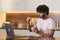 A mestizo young man stands sideways in the kitchen in subdued lighting, holds a bowl of pasta in hands and wraps them in