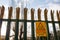 Metal anti climbing fence with spikes on top and warning sign. Secure perimeter of property