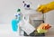 Metal basket with plastic bottles with detergents and disinfectants on a light background for cleaning and disinfection of the