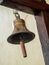 Metal bell hanging on wood stand at train station in thailand.