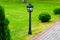 Metal black street lamp standing on green lawn