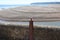 A metal bollard by the breakwater at the mouth of the river Axe near Axmouth in Devon