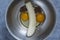 Metal bowl with eggs, ripe banana and cocoa powder for making banana pancakes. Funny food in the shape of a face