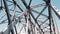 metal bridge. rough iron constructions against blue sky, filmed in motion from a car. bottom view. Railway and road