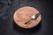 A metal cake blade with an empty brown cake stand on a dark concrete background